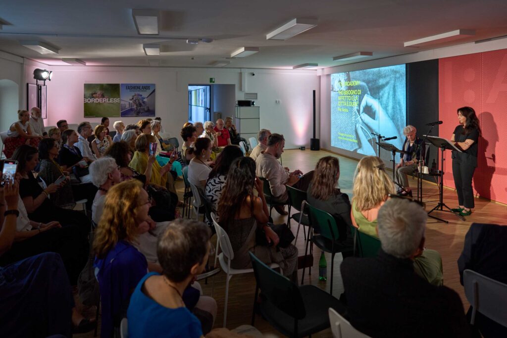 a group of people sitting in chairs in front of a projector screen