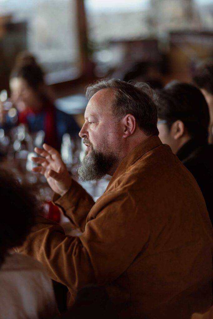 a man sitting at a table with a glass of wine