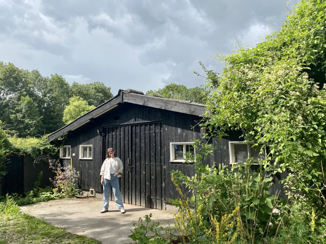 a man standing in front of a black building