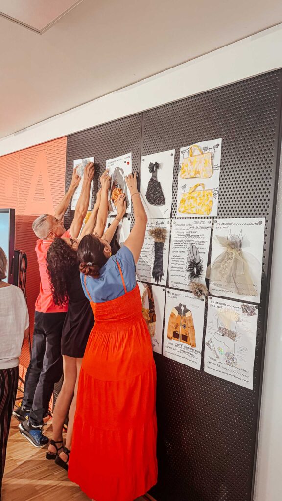 a group of people hanging pictures on a wall