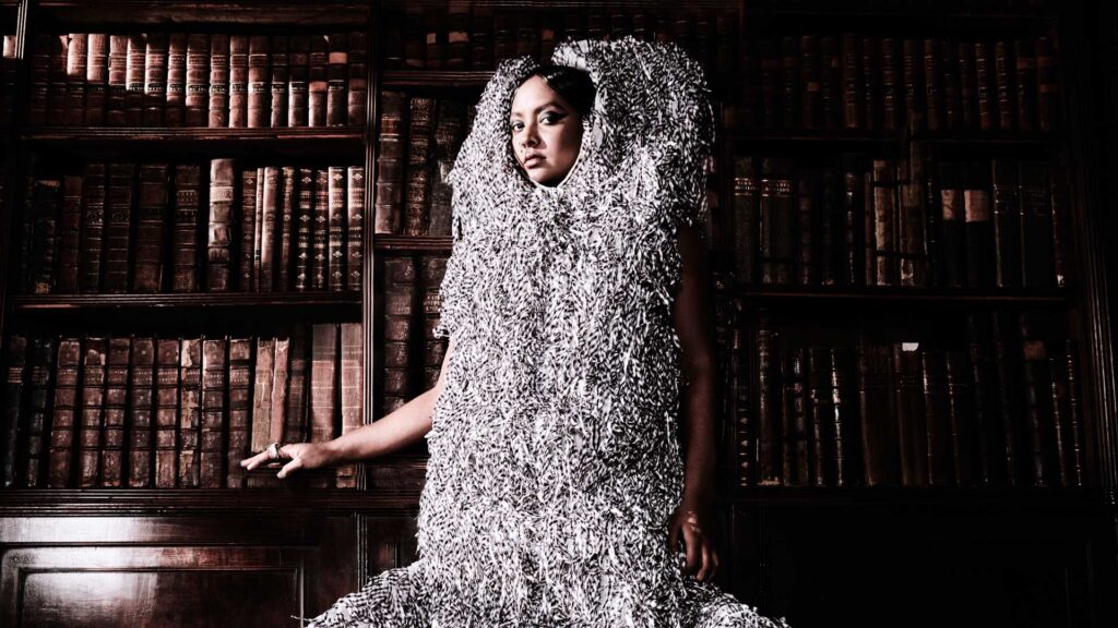 a woman standing in front of a bookshelf