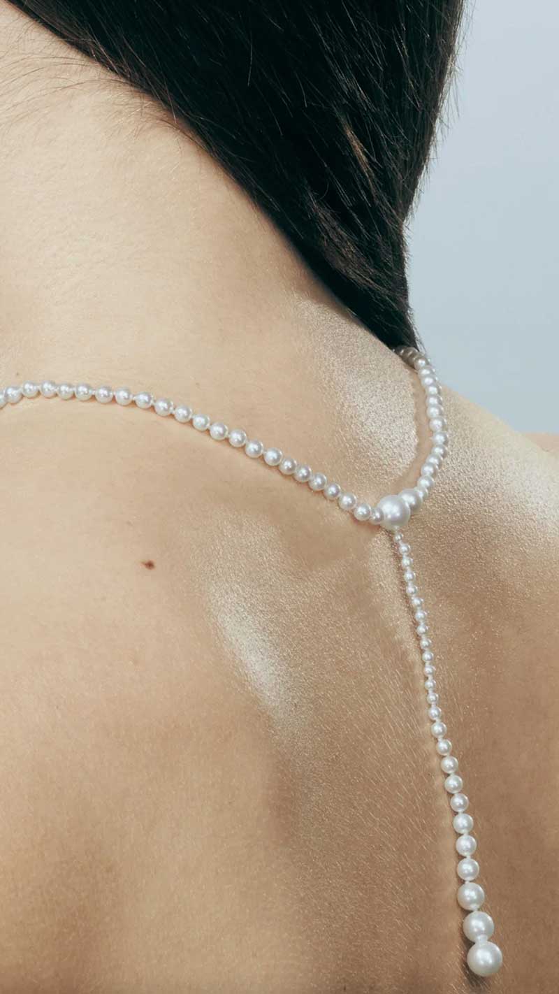 the back of a woman wearing a pearl necklace