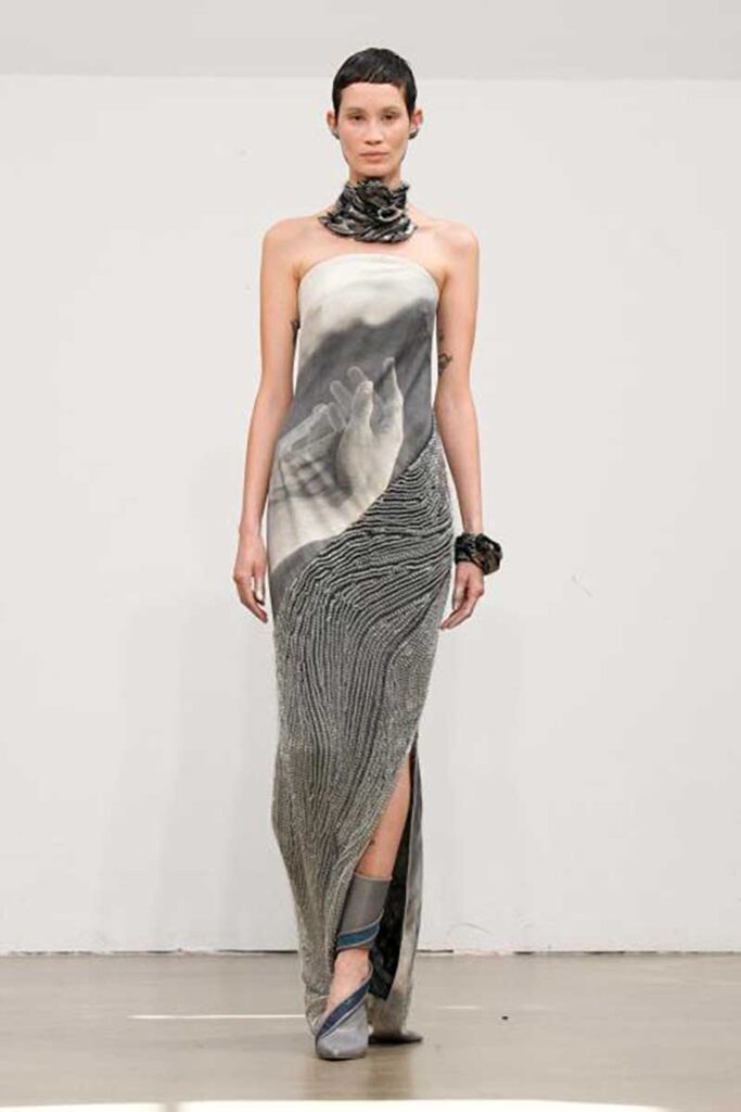 a woman walking down a runway in a dress
