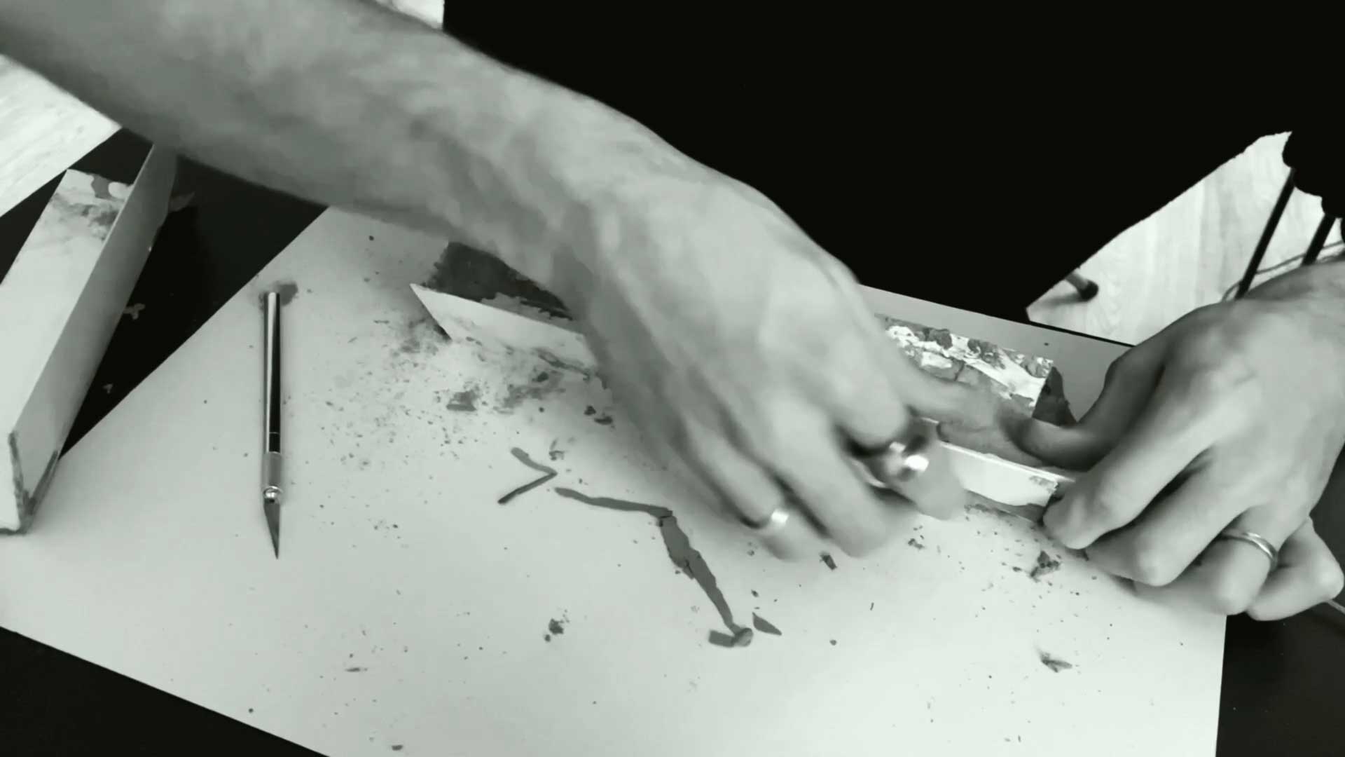 a black and white photo of a person working on a piece of art