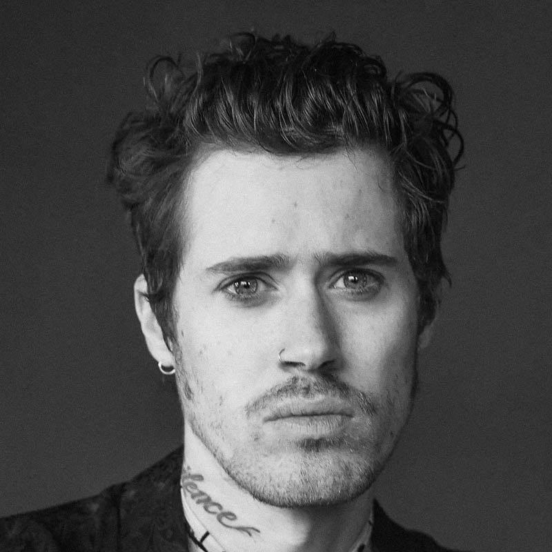 a black and white photo of a man with tattoos