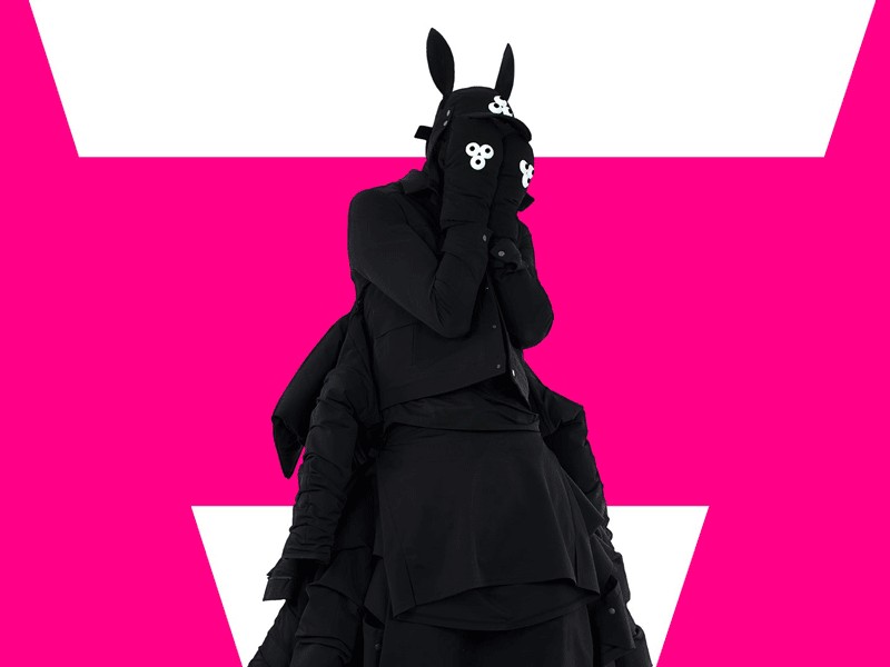 a person wearing a bunny mask and a black dress