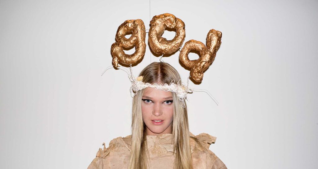 a woman with long blonde hair wearing a dress and gold balloons