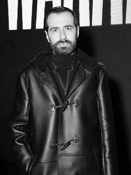 a man in a leather coat posing for a picture