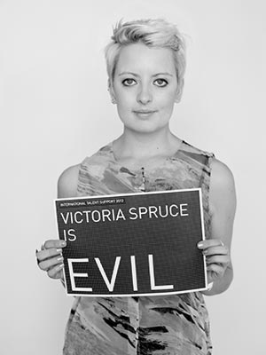 a woman holding a sign that says victoria spruce is evil