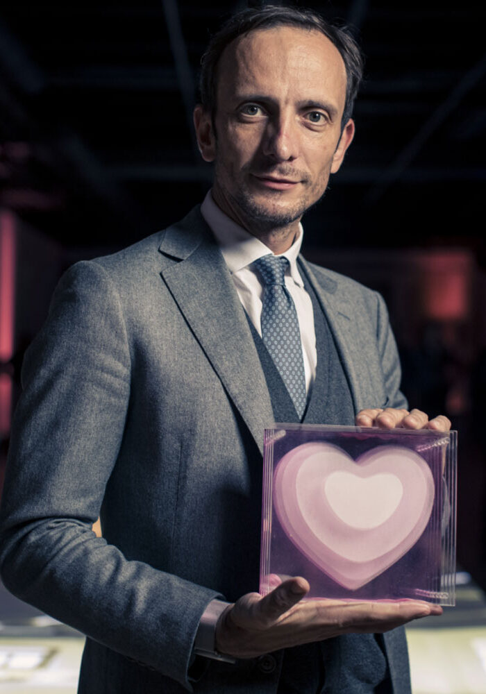 a man in a suit holding a box with a heart on it