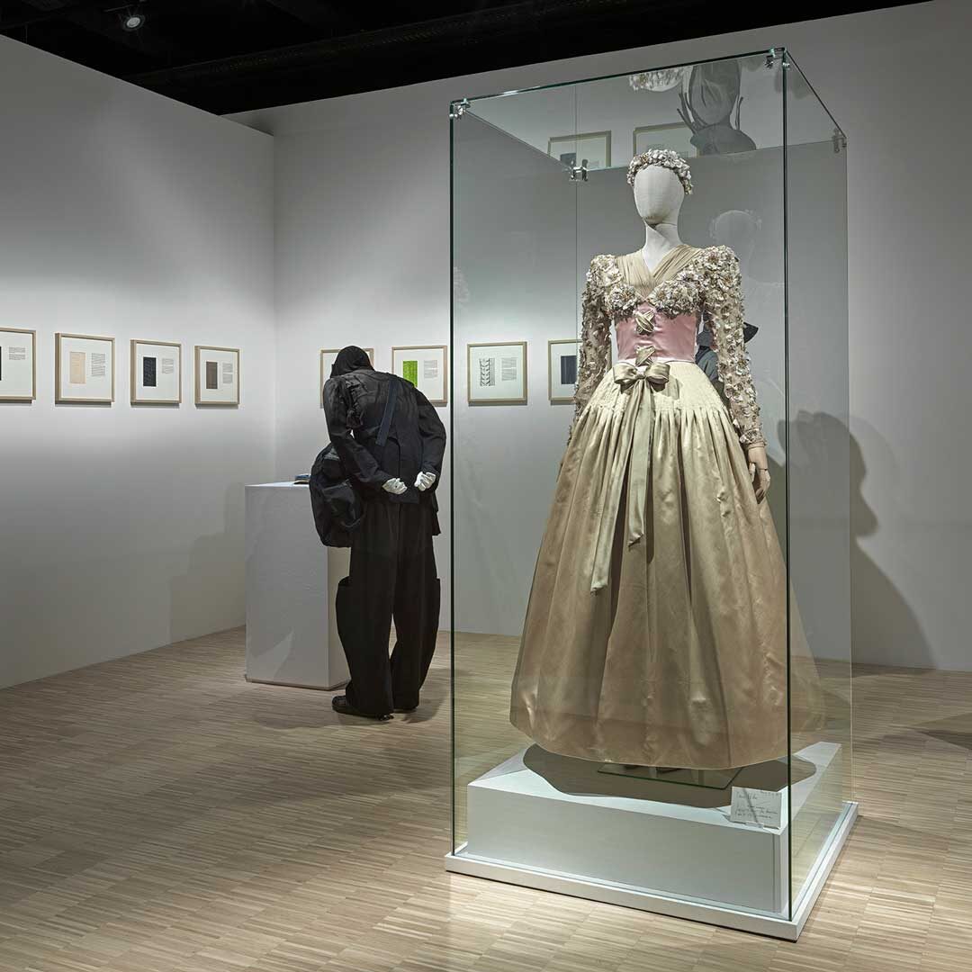 a man and woman looking at a dress on display