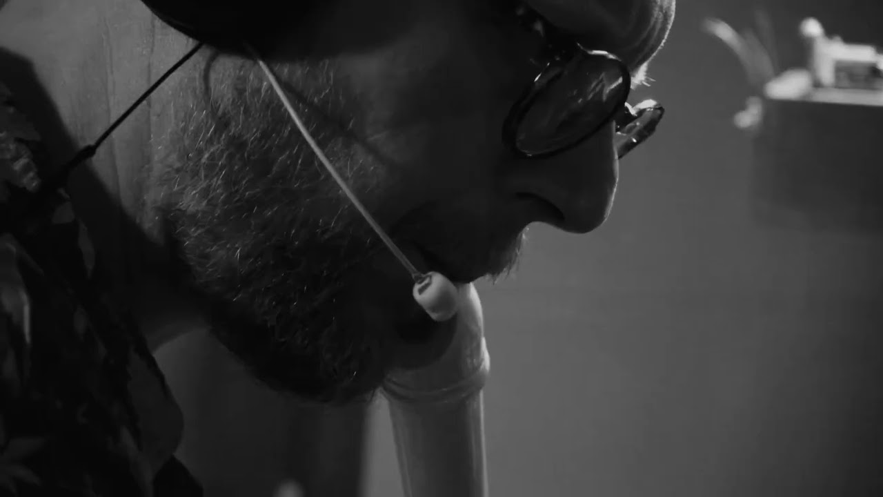 a man with a beard and glasses looking at a laptop
