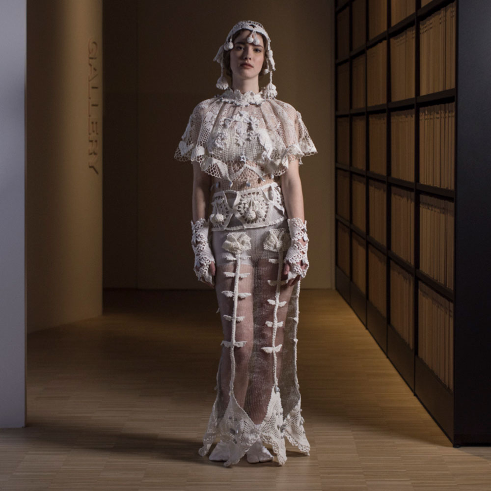 a woman in a white dress standing in a room