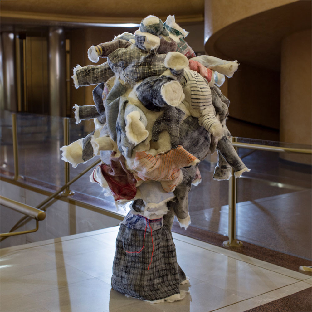 a sculpture of a pile of clothes sitting on top of a table