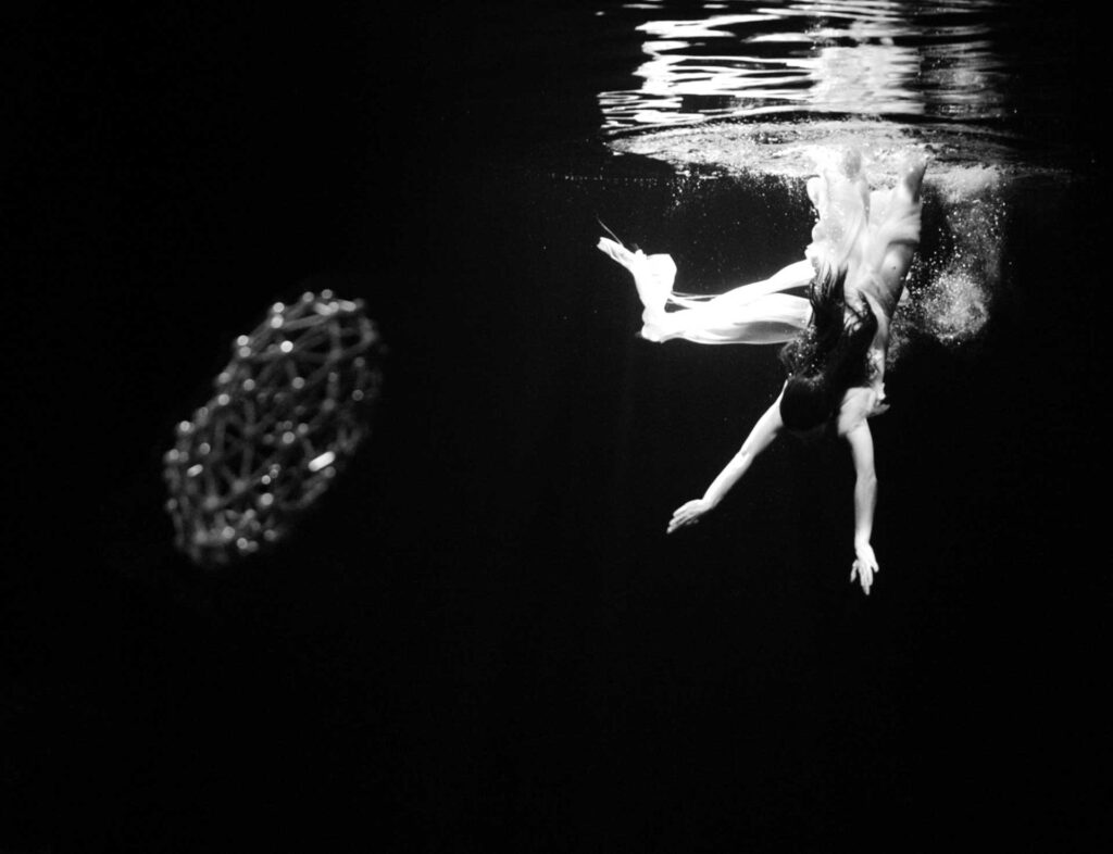 a woman swimming in the water with a net in front of her