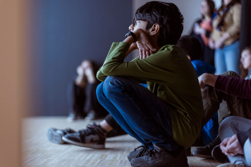 a man sitting on the floor in front of a group of people