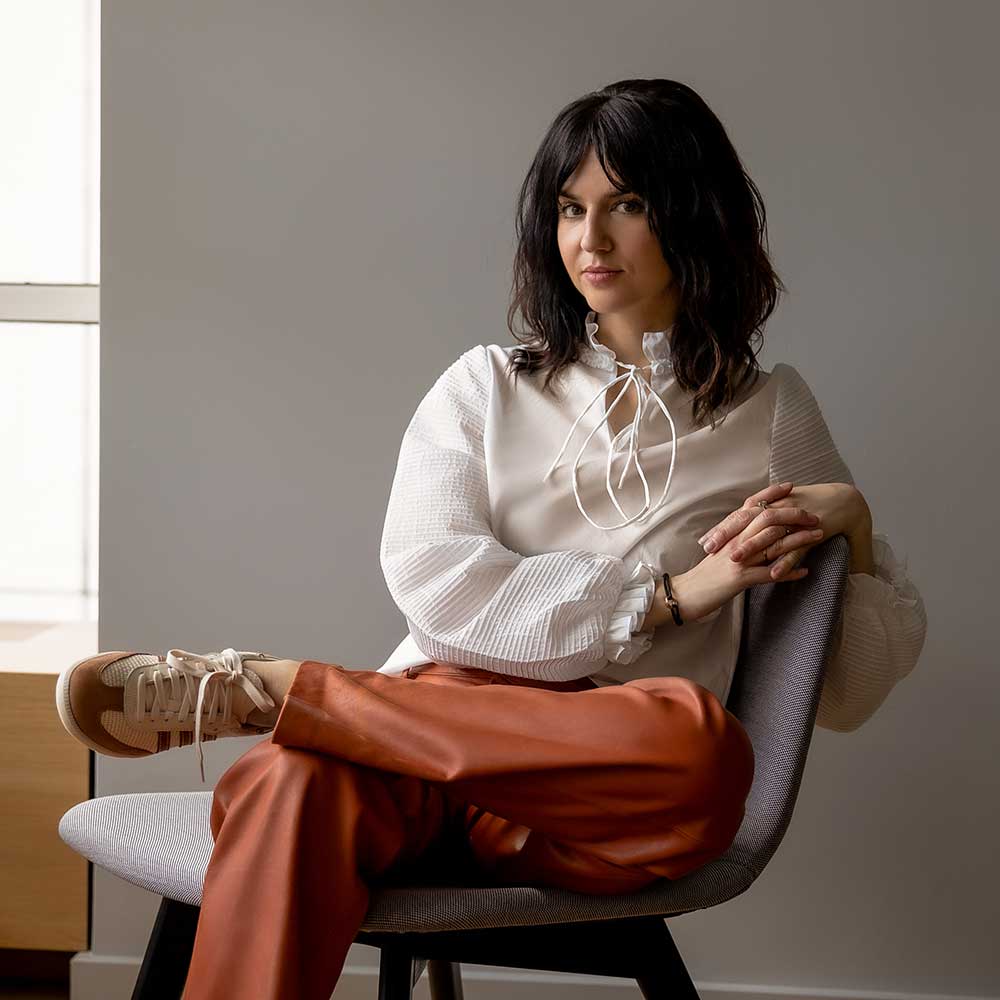 a woman sitting in a chair with her legs crossed
