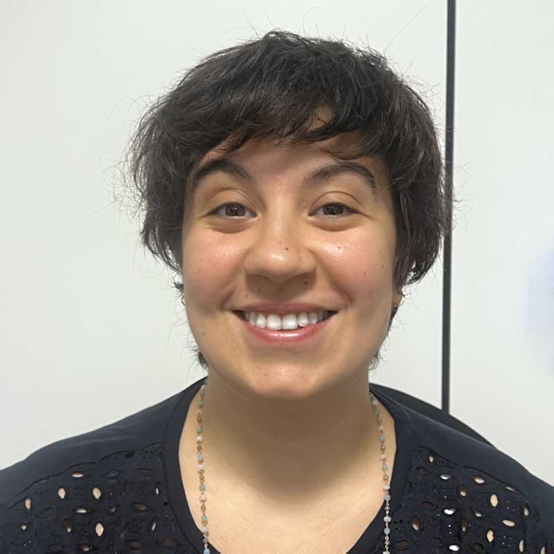 a woman with short black hair smiling at the camera