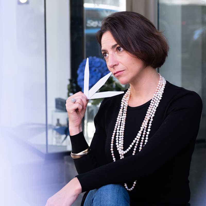 a woman holding a pair of scissors in front of her face