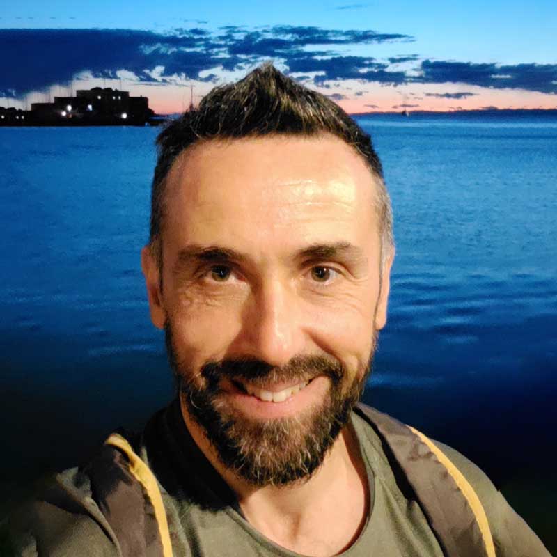 a man standing in front of a body of water