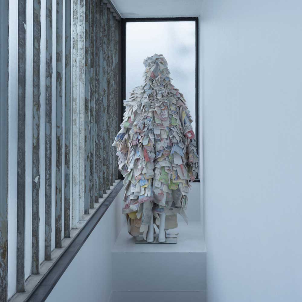 a person is standing on a staircase made out of newspapers